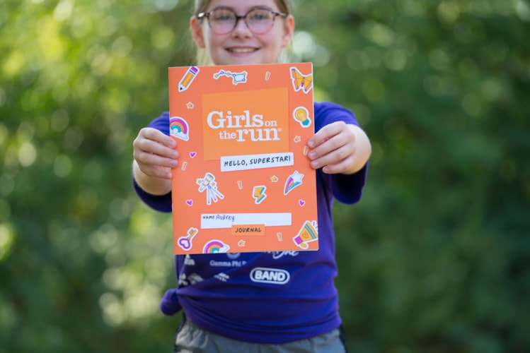 GOTR Participant smiles while holding a Hello, Superstar! journal out